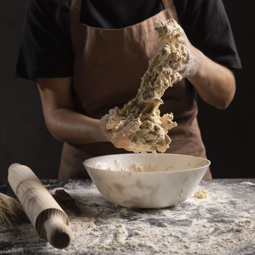 chef mixing dough with hands